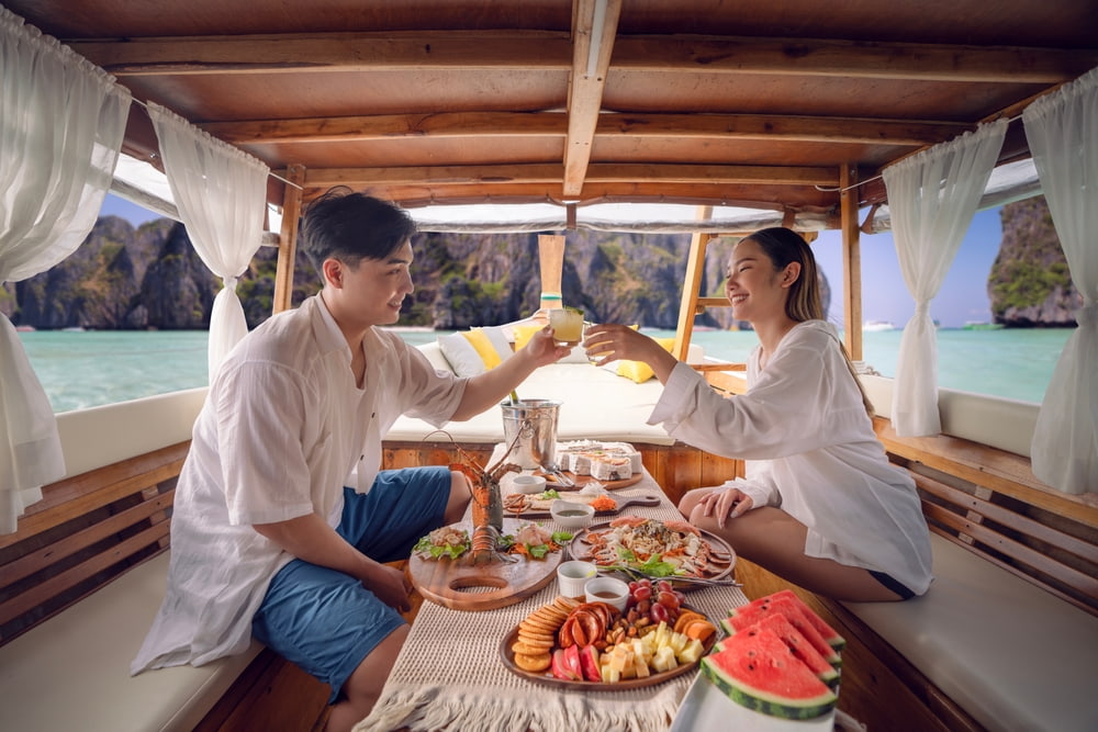 A couple enjoying seafood on a boat. Just one experience of why you should try Phuket seafood.