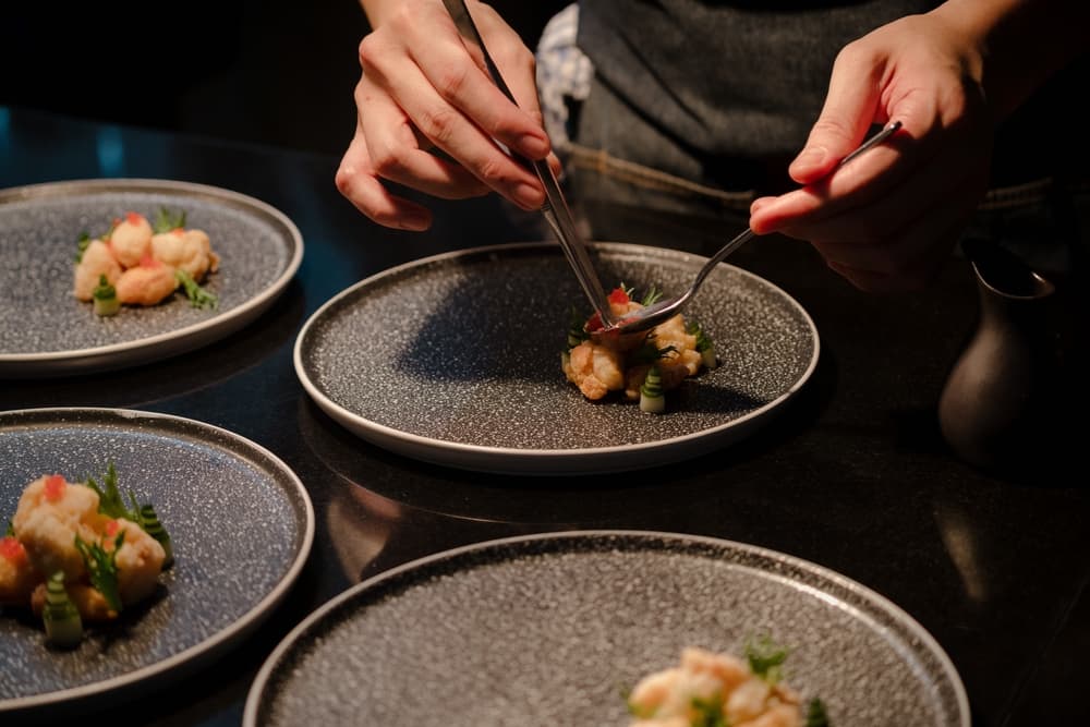 A chef preparing plates for guests at a Chef’s Table experience