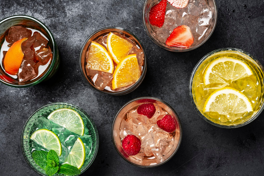 A selection of cocktails that pair with seafood, garnished with fresh citrus and berries
